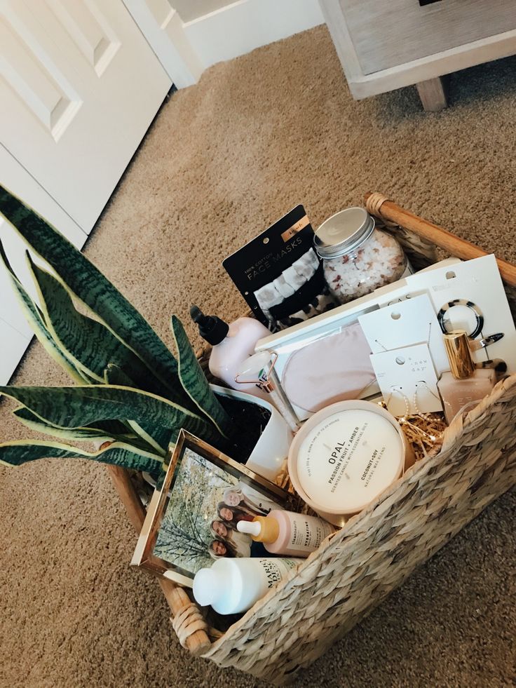 a basket filled with personal care items on the floor next to a potted plant