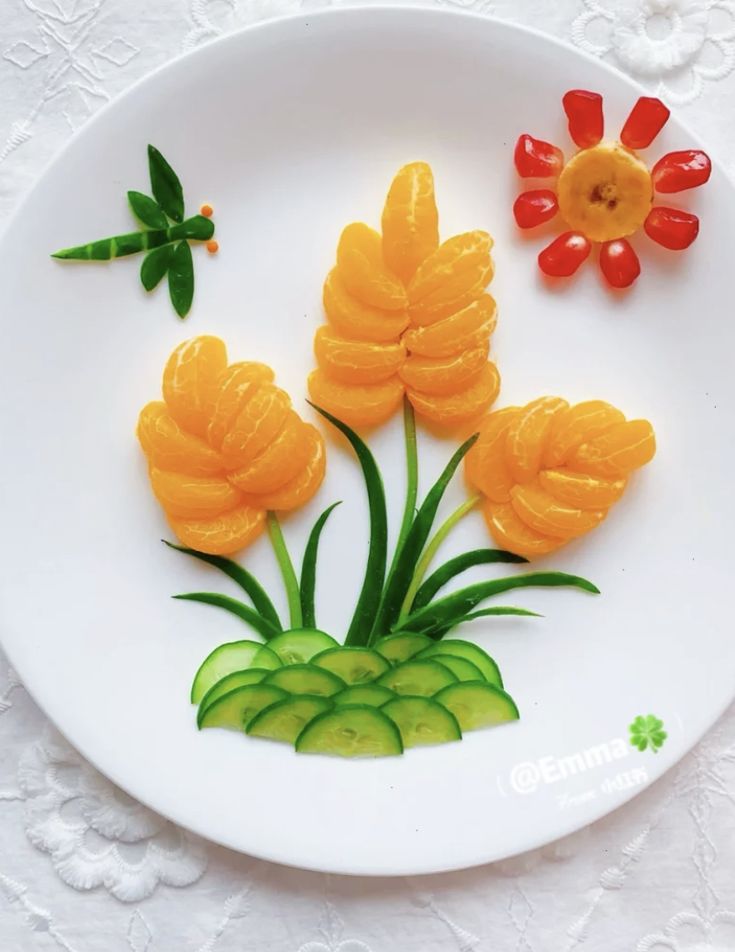 a white plate topped with orange flowers and cucumbers