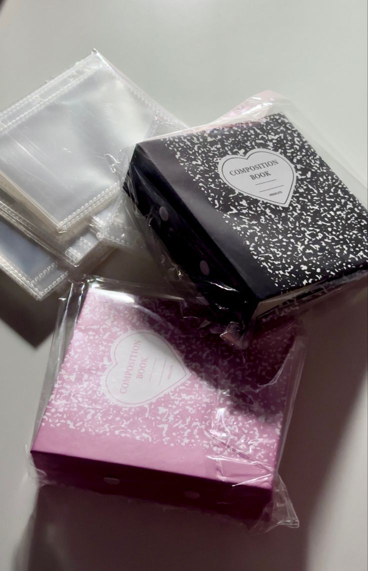 three different types of packaged items on a white table with black and pink packaging in the middle