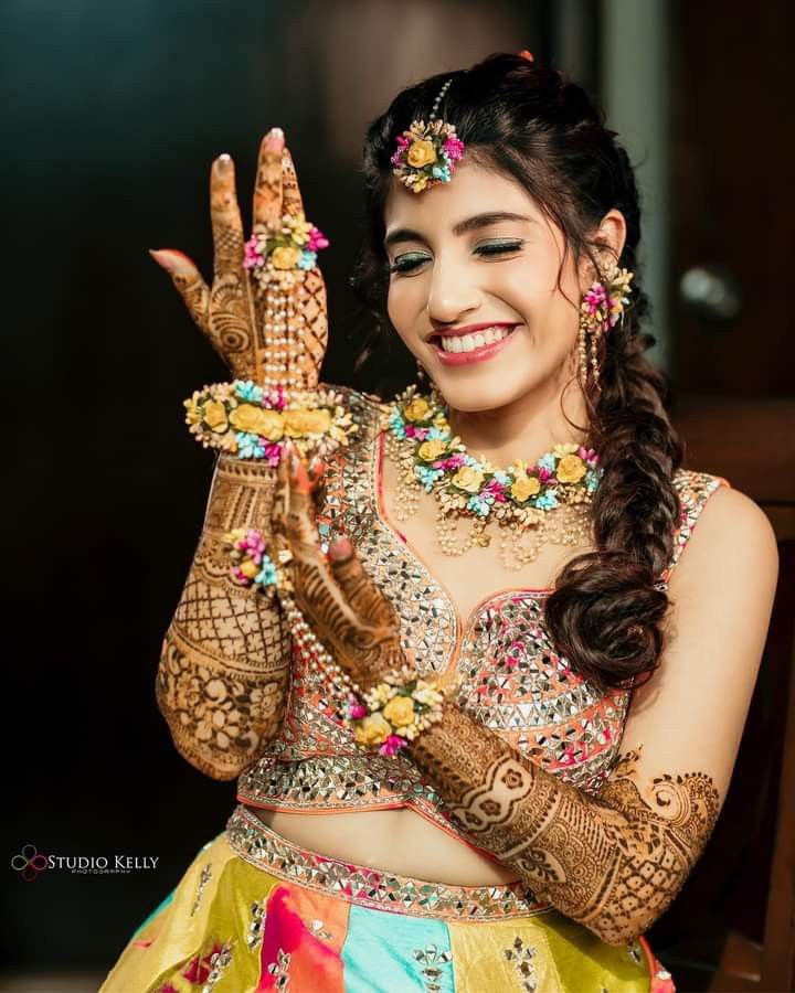 a woman with henna and jewelry on her hands holding something up to the camera