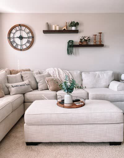 a living room filled with furniture and lots of pillows on top of it's couches