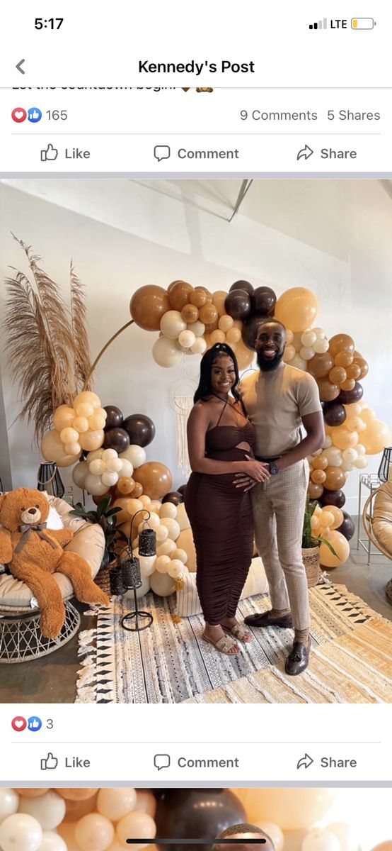 two people standing next to each other in front of balloons