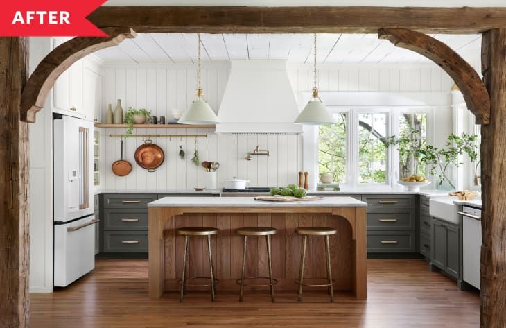 an open kitchen with two stools in front of the island and wooden beams on the ceiling