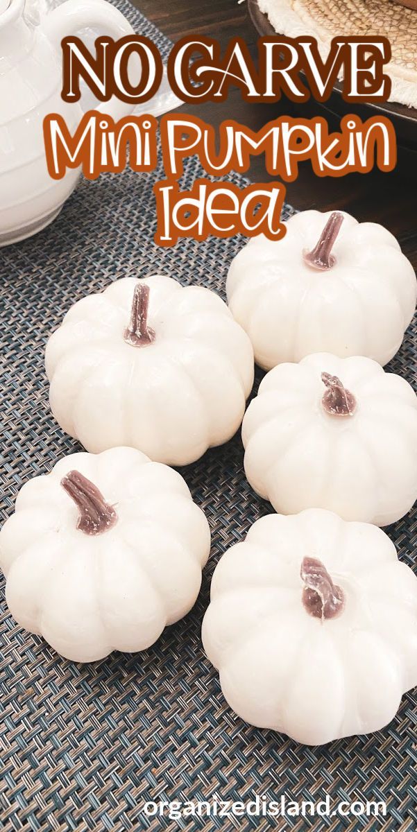 four white pumpkins sitting on top of a table next to a cup and saucer