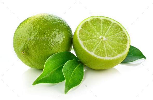 two limes with leaves and one cut in half on white background - stock photo - images