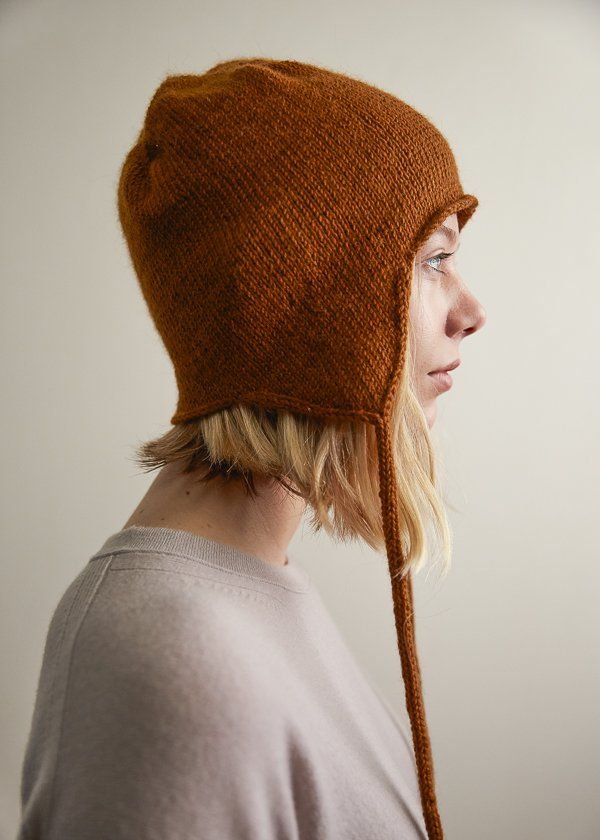 a woman wearing a brown knitted hat