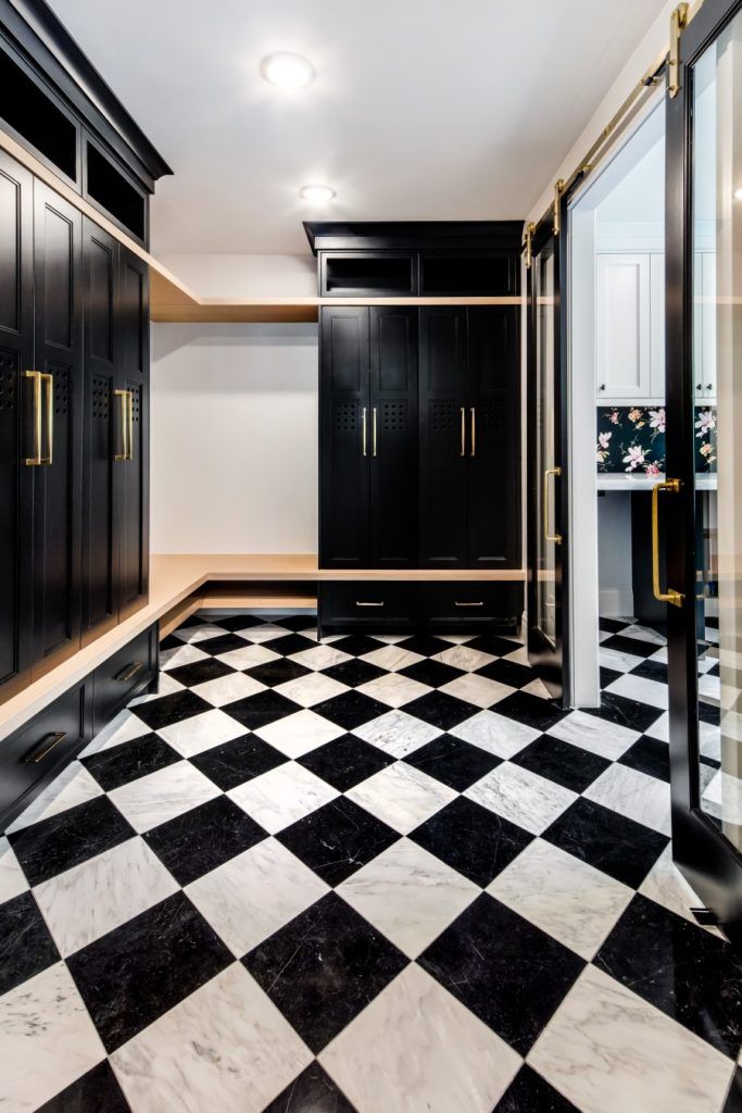 a black and white checkered floor in a walk - in closet with mirrored doors