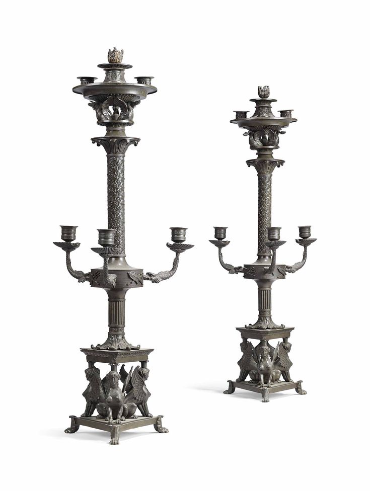 two metal candelabras sitting next to each other