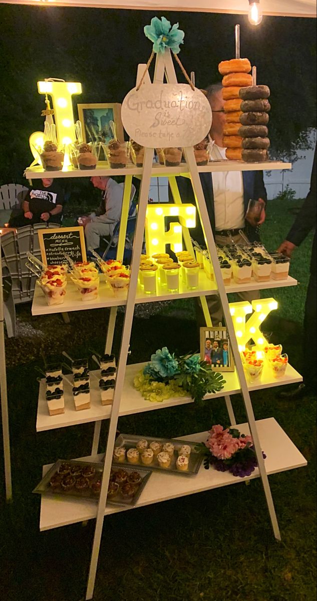 an outdoor dessert stand with lights on it