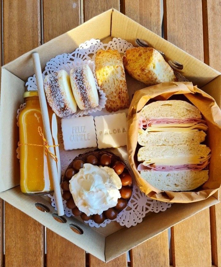 a box filled with lots of different types of food on top of a wooden table