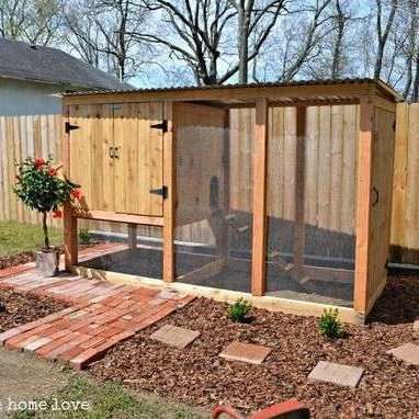 a chicken coop in the middle of a yard with plants and flowers growing inside it