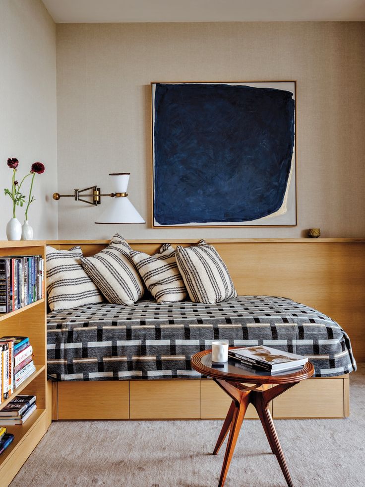 a bed sitting in a bedroom next to a book shelf