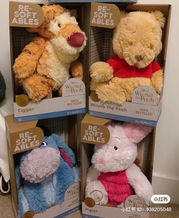 three stuffed animals in boxes on the floor