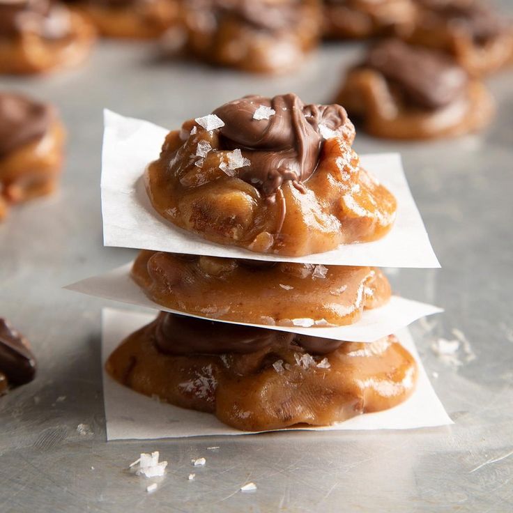 three chocolate covered doughnuts stacked on top of each other with napkins around them