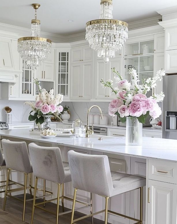 a kitchen with white cabinets and chandelier hanging from the ceiling, along with four bar stools