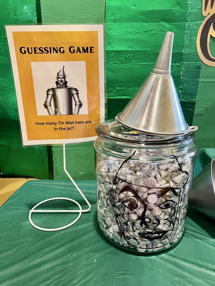 a glass jar filled with candy sitting on top of a table next to a sign