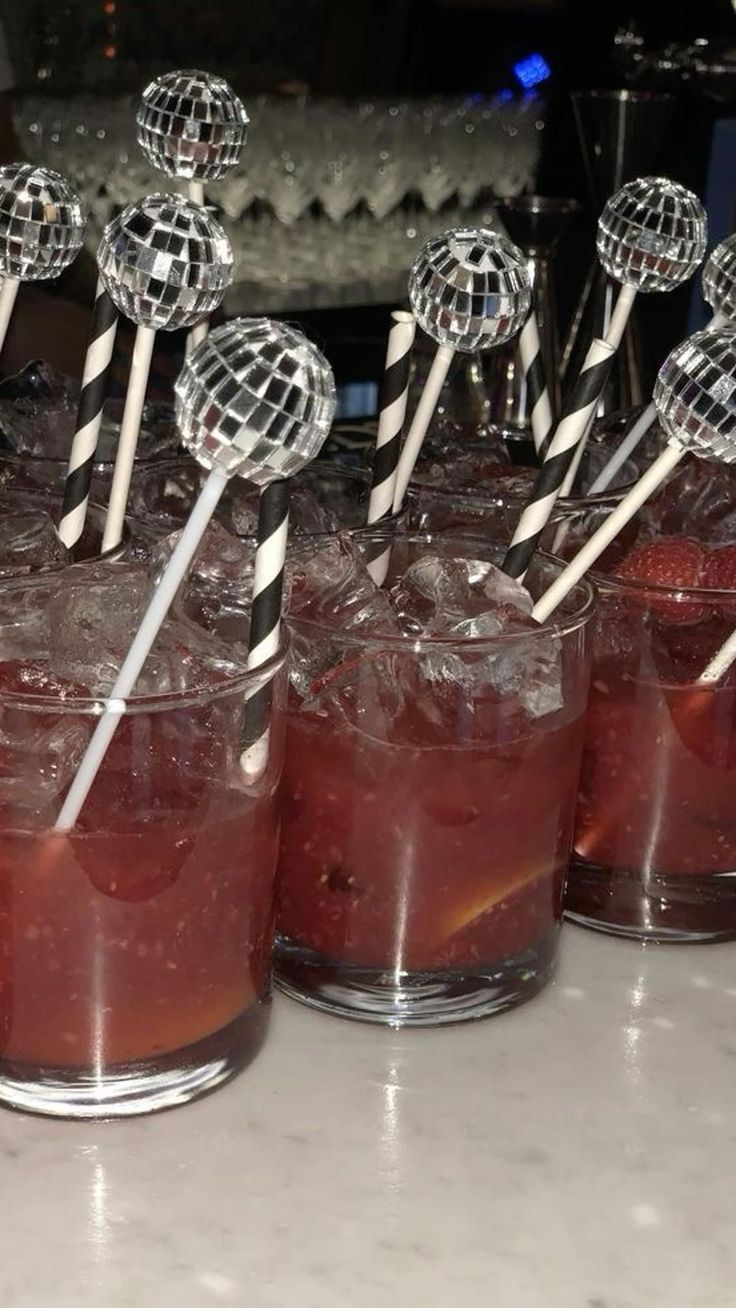 several cocktails with lollipop sticks sticking out of them