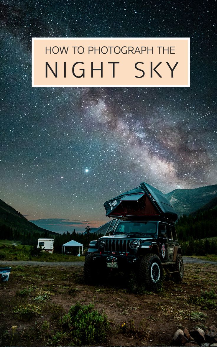 a jeep parked in the middle of a field under a night sky filled with stars