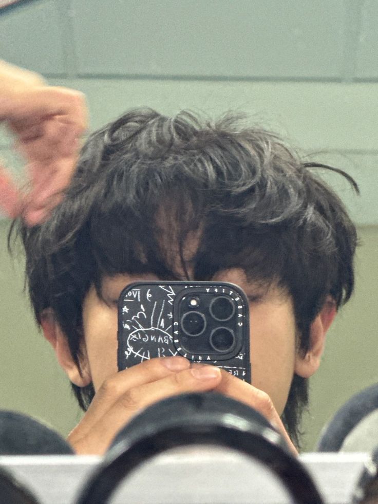 a man taking a selfie in front of a mirror with his cell phone up to his face