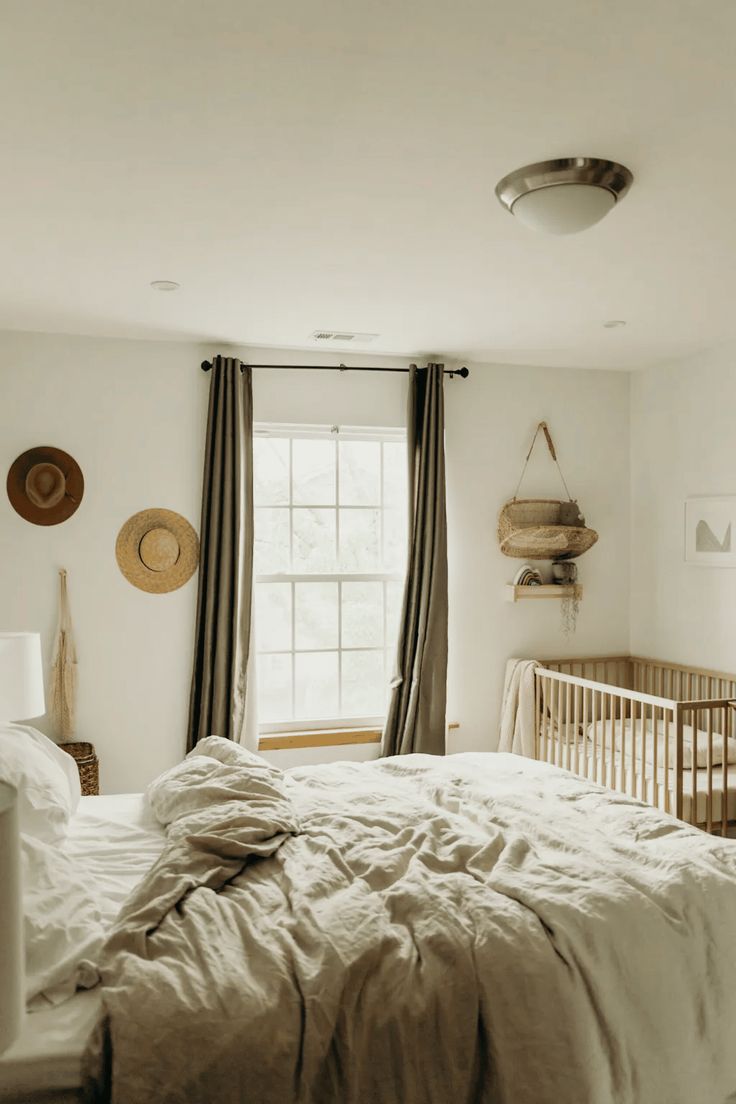 a bedroom with a bed, crib and window in it's center area