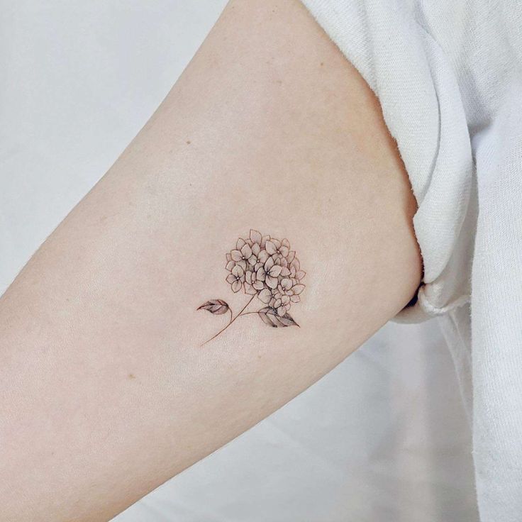 a woman's arm with a flower tattoo on the left side of her body