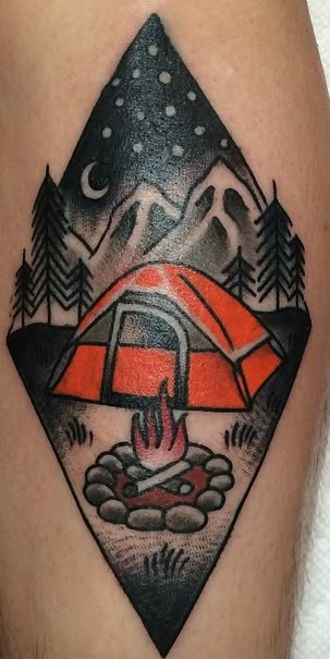 a man's leg with a campfire and tent tattoo on it