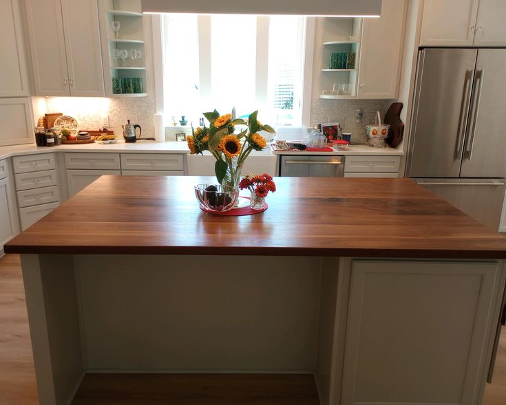 a large kitchen island with sunflowers in the center and cabinets on both sides