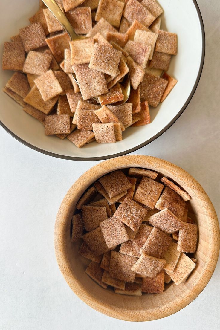 two bowls filled with sugar cubes on top of a white counter next to each other