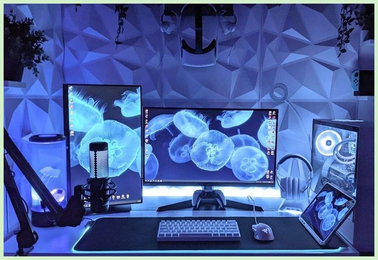 two computer monitors sitting on top of a desk next to a keyboard and monitor screen