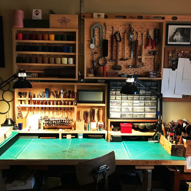 a workbench with lots of crafting supplies and tools on the shelves above it