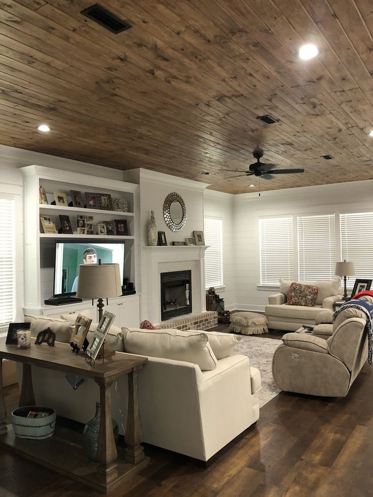 a living room filled with furniture and a fire place in the middle of it's walls