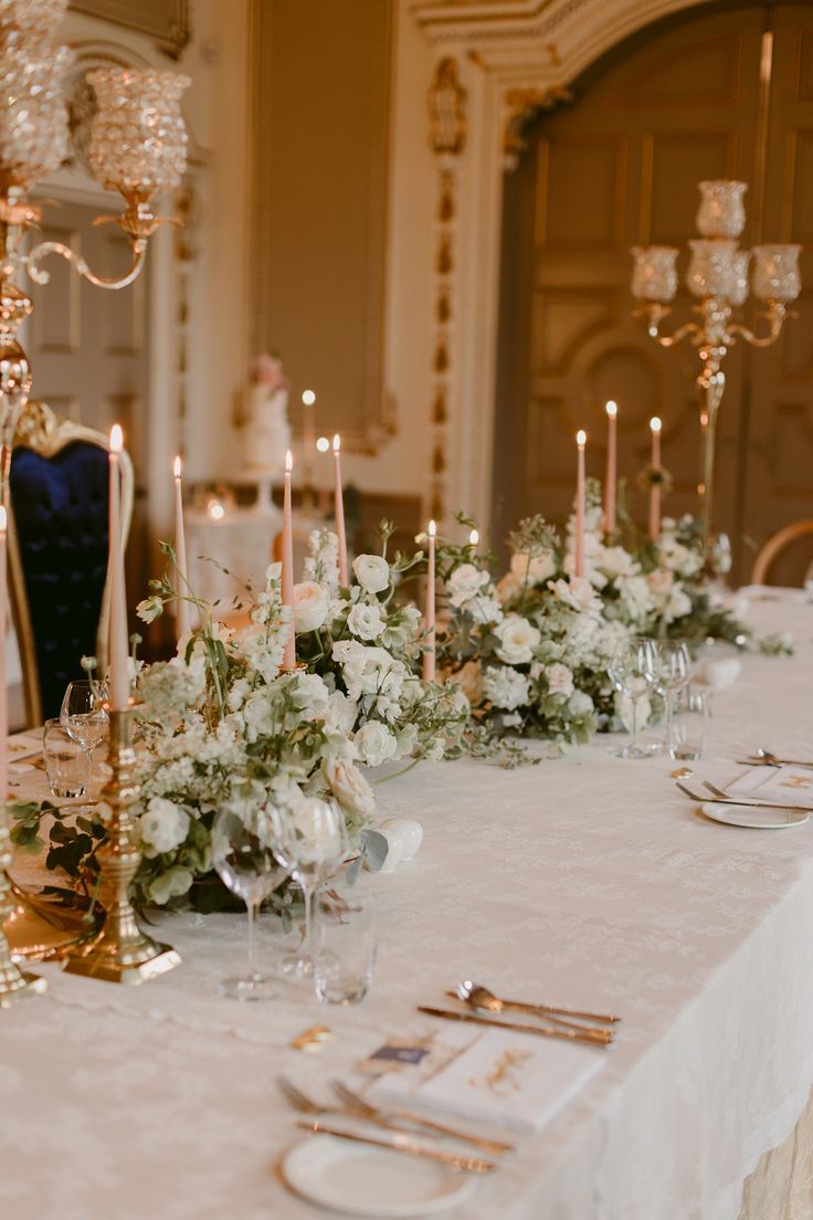 the table is set with candles, flowers and place settings for an elegant wedding reception