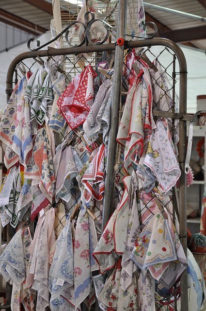 many different colored handkerchiefs are hanging on a rack