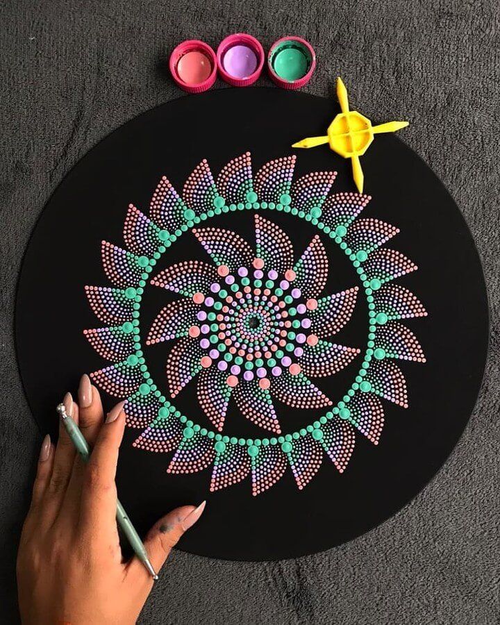 someone is drawing on a black surface with colored markers