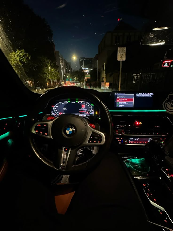 the interior of a car at night with dashboard lights and electronic displays on the wall