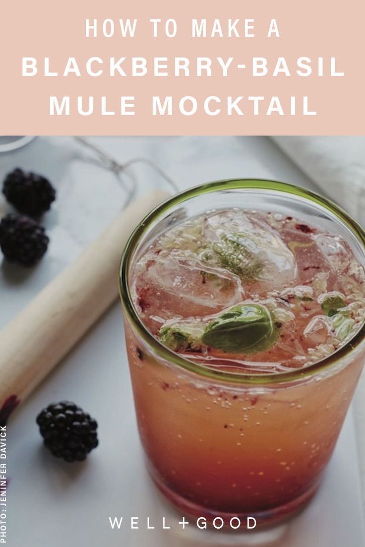 a blackberry - basil mule cocktail in a mason jar with fresh blackberries on the side