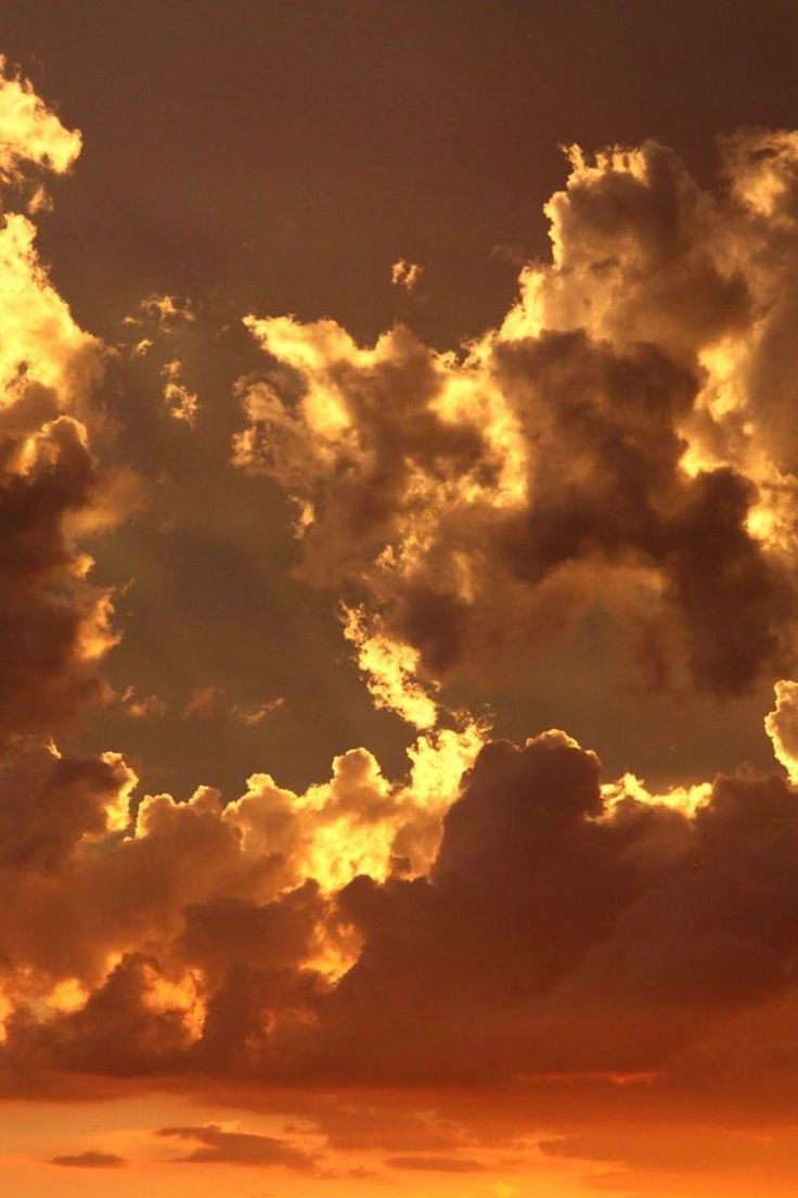 an airplane flying in the sky at sunset with clouds and sunbeams behind it