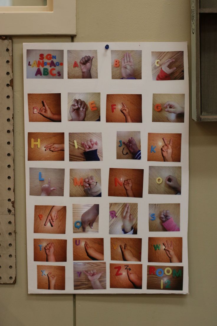 a bulletin board with pictures of hands and letters on it's side hanging on a wall