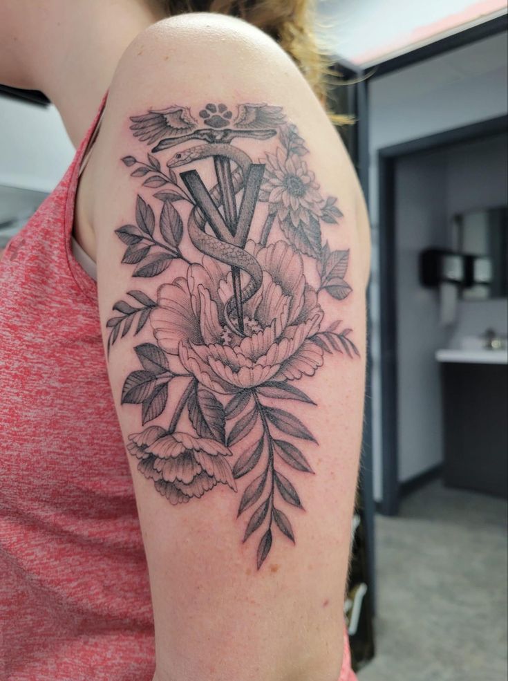 a woman with a tattoo on her arm and flowers in the middle of her arm