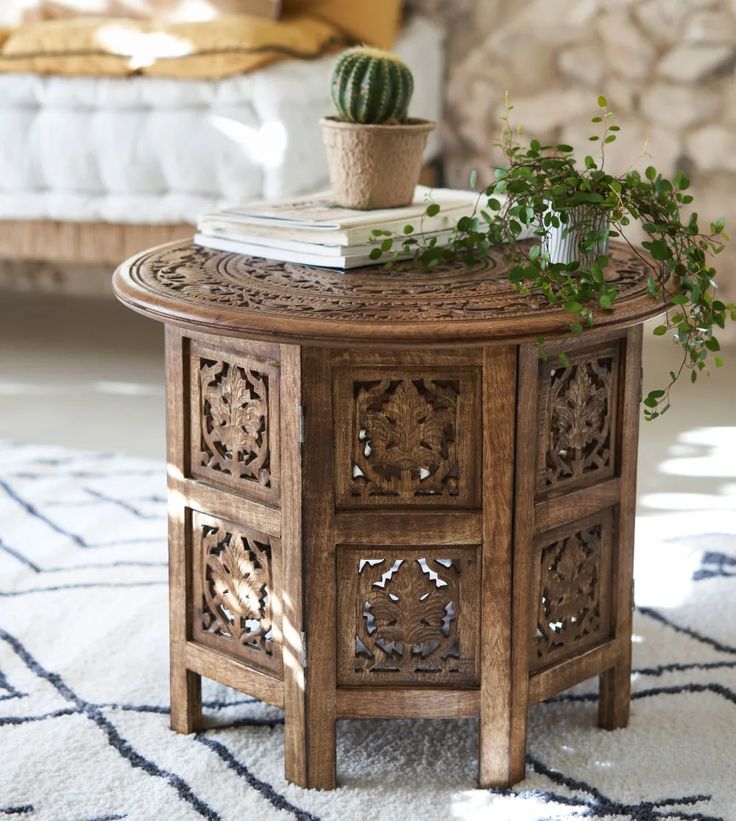 a table with a potted plant on top of it in front of a couch