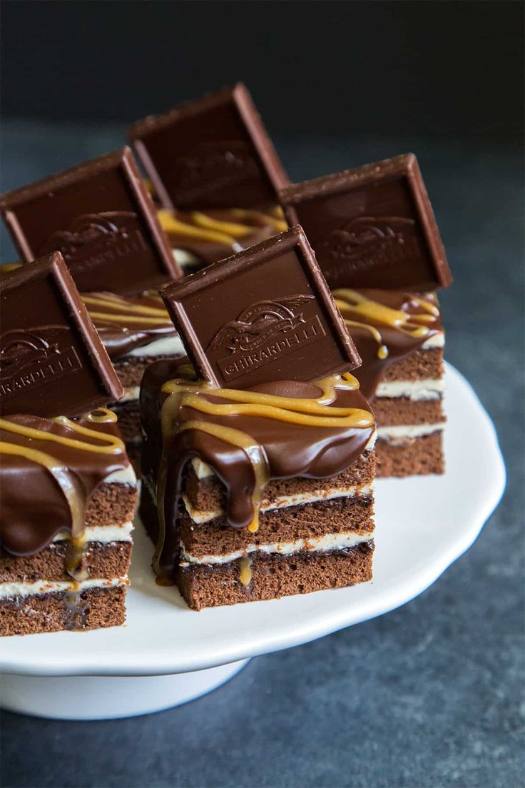 several pieces of cake on a plate with chocolate and caramel drizzles