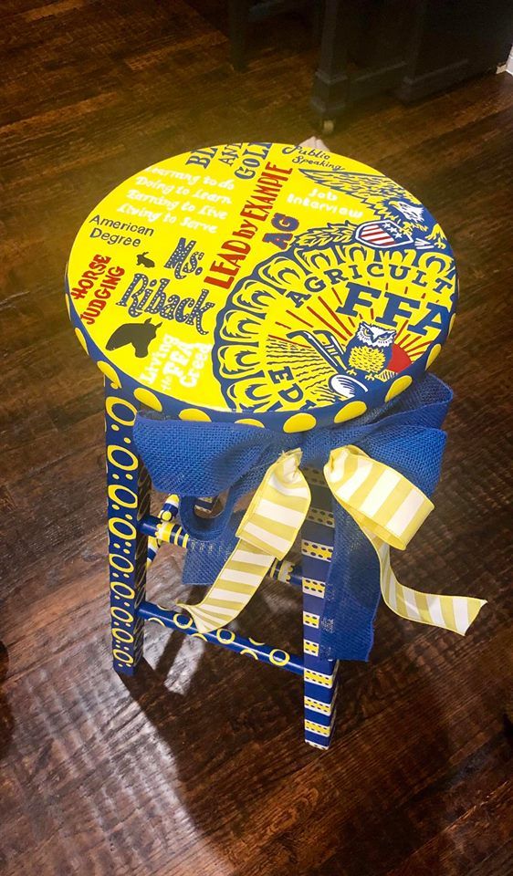 a yellow and blue stool on top of a wooden floor