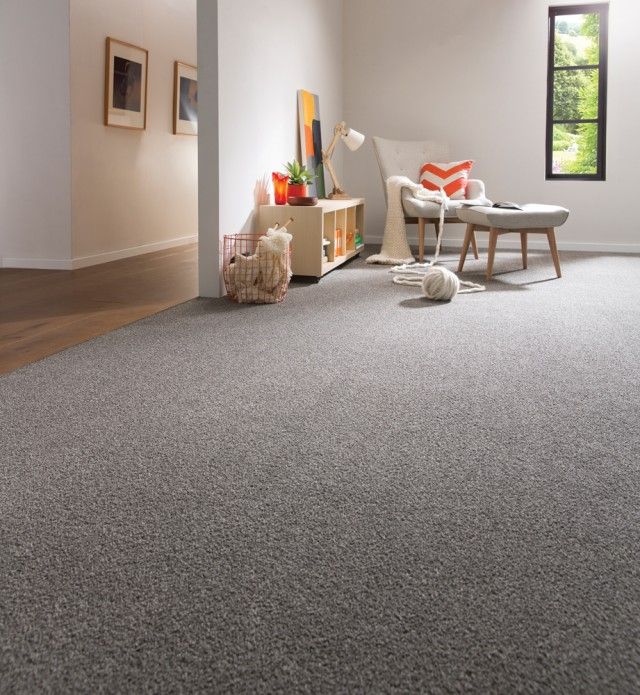 a living room with gray carpet and white furniture