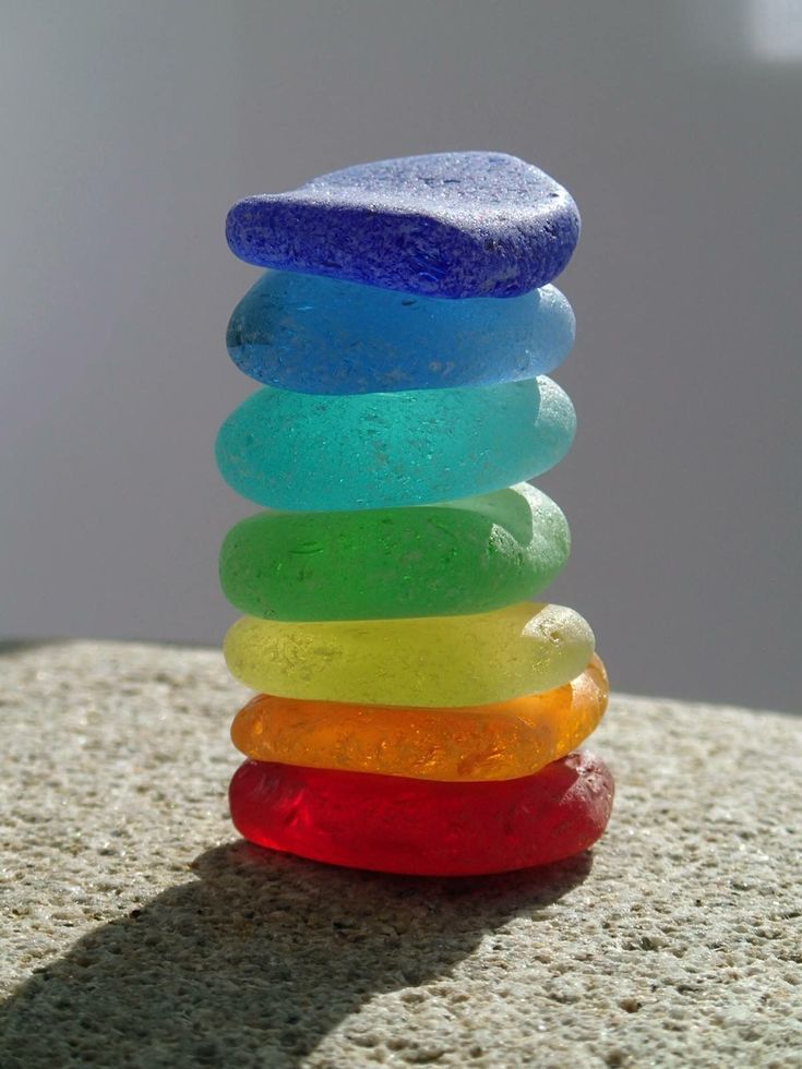 a stack of colorful rocks sitting on top of a rock