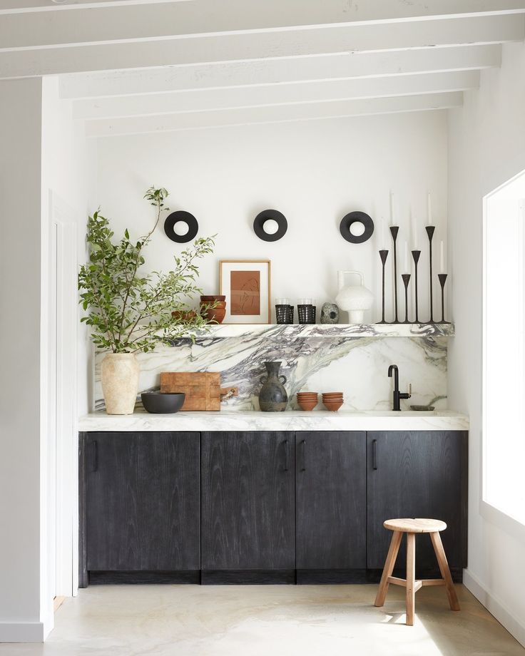 a kitchen with marble counter tops and black cabinets