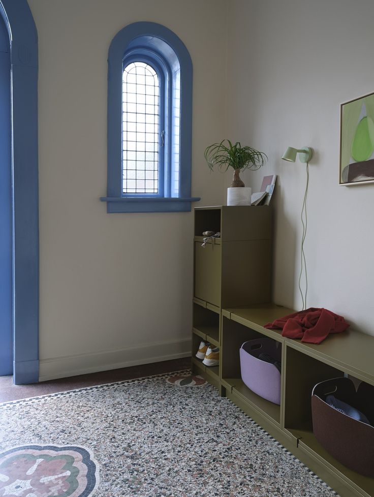 a room with a blue window and a rug on the floor