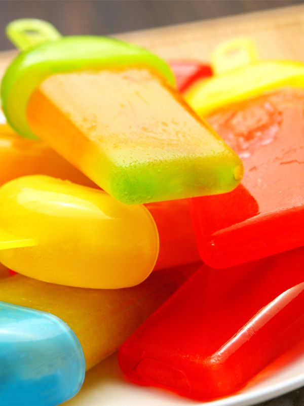 colorful popsicles are sitting on a white plate