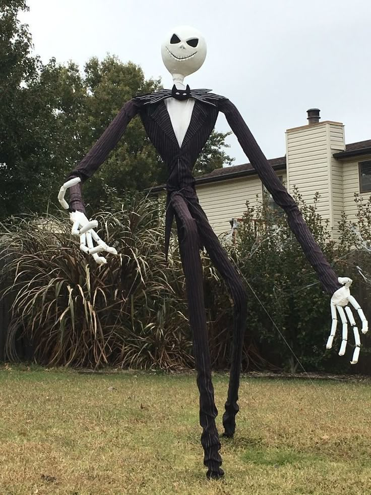 an inflatable jack skellingy with hands and feet is standing on the lawn