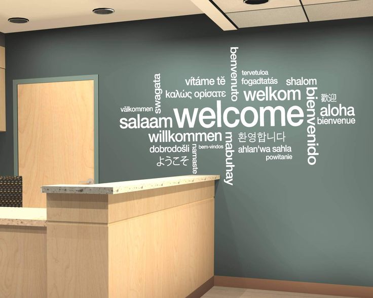 a welcome sign is displayed on the wall in an office setting with wood cabinets and blue walls