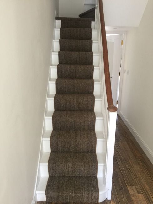 a staircase with carpeted steps leading up to the second floor